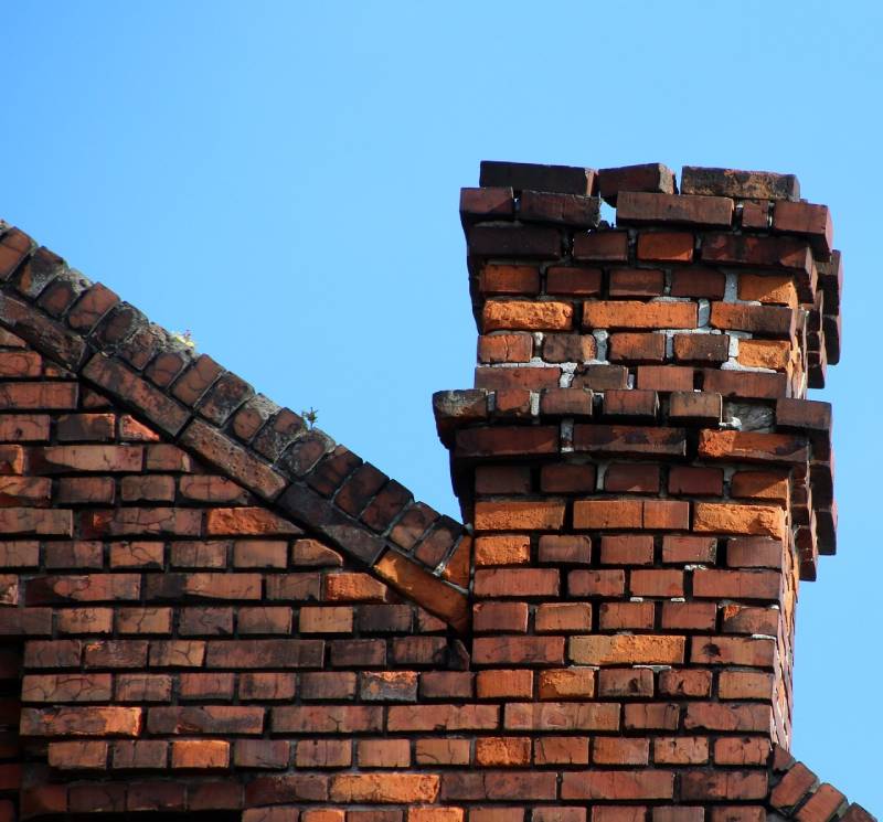 Damaged chimney on an National City home showing cracks and missing mortar